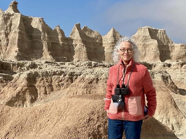 woman with binoculars standingin the Badlands National Park