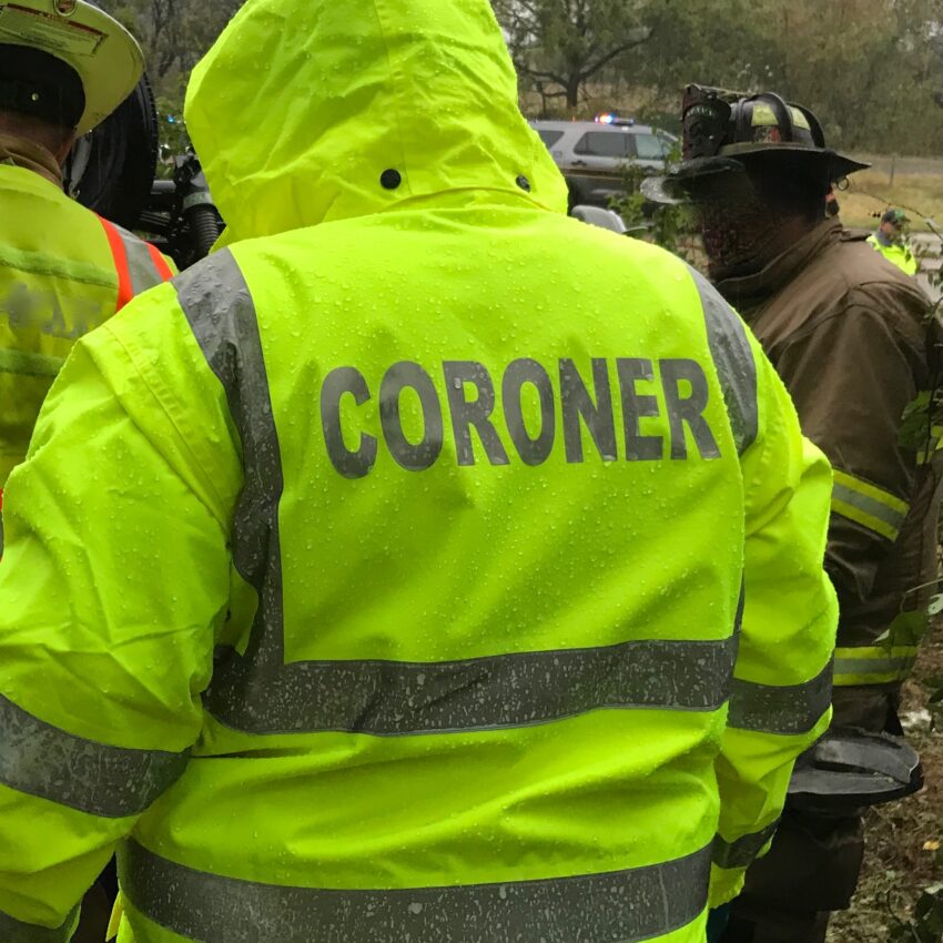 image of back of a coroner in neon-yellow rain jacket