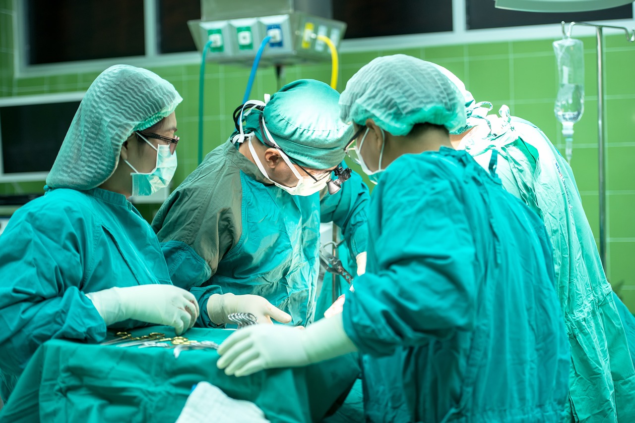 photo of gowned and masked surgeons gathered around a surgical table