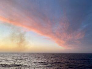 View of an ocean with red clouds from impending storm