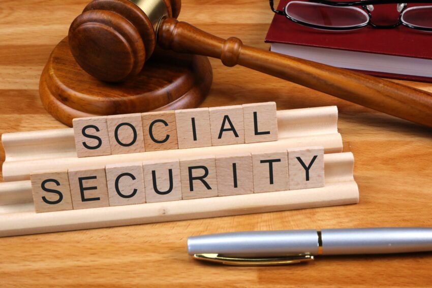 Photo of scrabble letters spelling the words Social Security, plus a gavel, and a pen