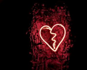 decorative image of white neon heart on red and black background