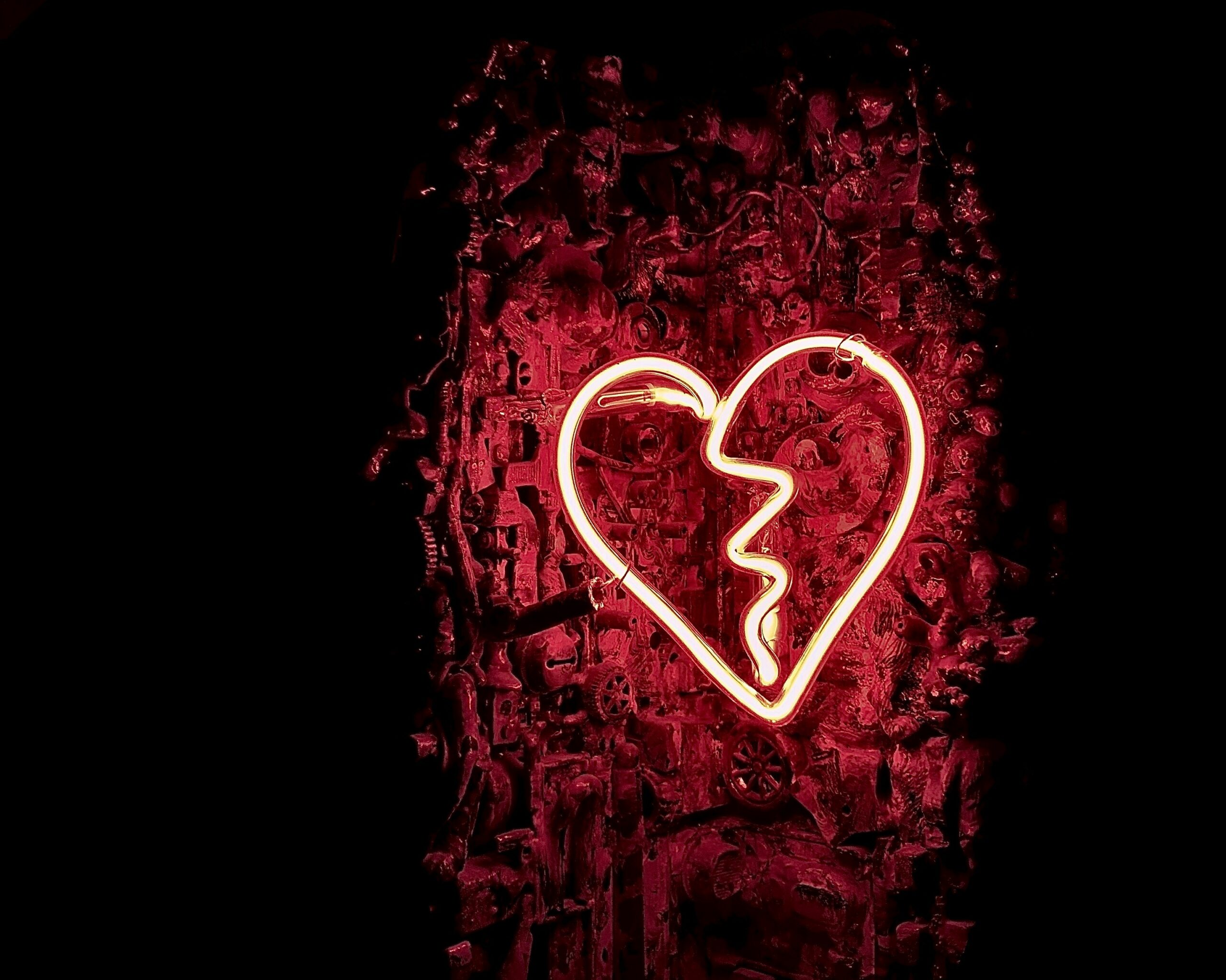 decorative image of white neon heart on red and black background